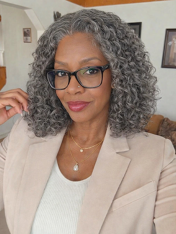 Front view of a medium-length salt and pepper gray wig with loose water wave curls, worn by a real model wearing glasses, made of 100% human hair, ideal for natural, elegant everyday styling