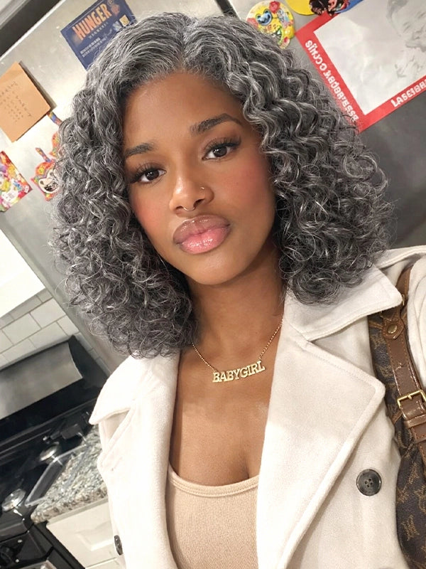 Front view of a medium-length salt and pepper gray wig with loose water wave curls, worn by a young real model, made of 100% human hair, perfect for natural, elegant everyday styling