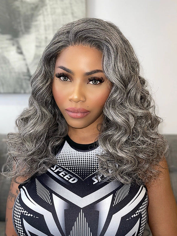 Mature African American woman wearing Luvwin Salt & Pepper Loose Wavy Kinky Hair Wig, soft natural waves, realistic gray highlights, glueless lace front, 100% human hair, easy-to-style and beginner-friendly wig for stylish Black women