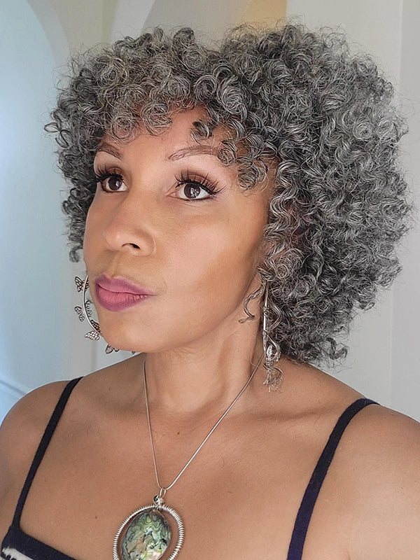 Elegant mature woman wearing Luvwin Salt and Pepper Ringlet Curls Wig with Bangs, styled for a special occasion, showing natural volume and shine, suitable for weddings or formal gatherings.