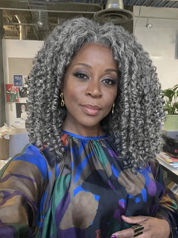 Black woman wearing realistic salt and pepper curly gray bob wig, soft natural afro curls, elegant short gray hairstyle for mature professional women.